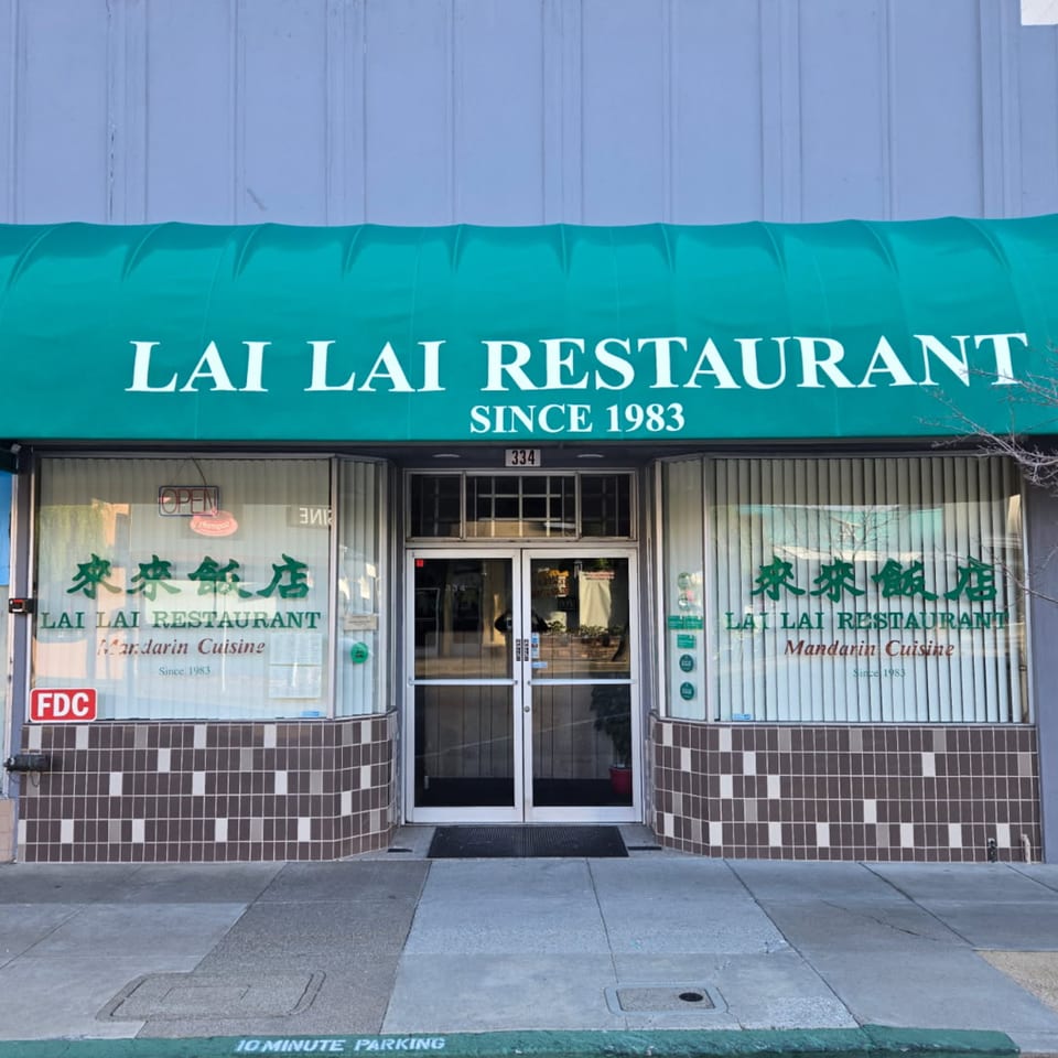 Exterior of Lai Lai Restaurant, a Chinese restaurant, with a green awning and glass doors.